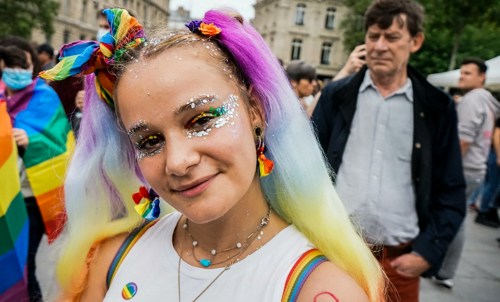 A person with dyed hair and Rainbow flags at Dublin Pride parade