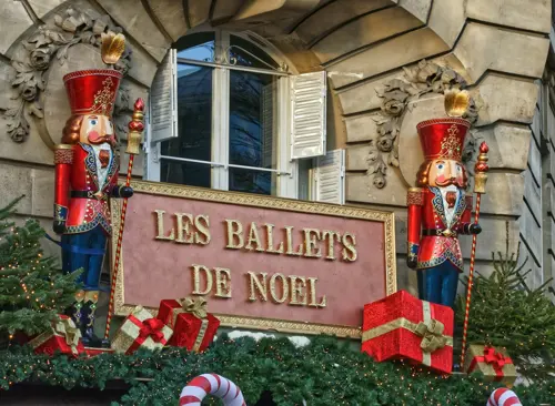 Nutcrackers stand on either side of a sign "les ballets de Noel"