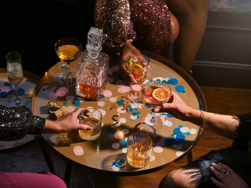 Christmas drinks on round table with hands reaching